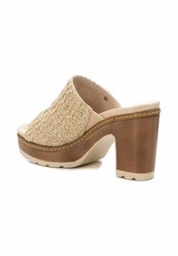 Mule in piattaforma beige con tomaia testurizzata e intrecciata, caratterizzati da un tacco sintetico color tan e una suola chiara. Design a punta arrotondata.