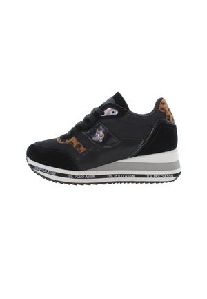 Zapatilla deportiva negra con parte superior de ante y cuero, detalles de estampado de leopardo y una entresuela blanca con la marca en la parte inferior.
