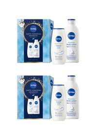 Nivea Creme Soft Duschcreme und Express Körperlotion Flaschen neben dekorativen blauen und goldenen Geschenkboxen mit der Aufschrift "Sanfte Momente".