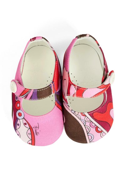 Scarpe in tessuto rosa e rosso con punta tonda, cinturino con chiusura a bottone e motivi astratti colorati con forme curve.