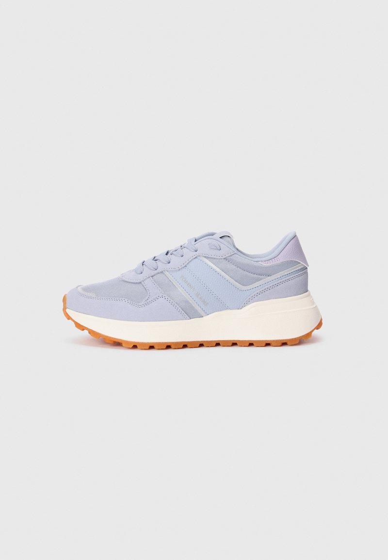Baskets de sport bleu clair en matériaux mesh et daim, à bout rond, avec un système de laçage et une semelle en caoutchouc orange. Présente des accents rayés.
