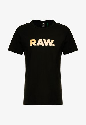 Schwarzes T-Shirt mit kurzen Ärmeln und fettem, beigem Großbuchstaben-Text "RAW." zentriert auf der Brust, mittlere Größe, runder Halsausschnitt.