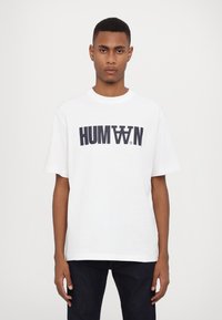 White cotton t-shirt with short sleeves, featuring bold navy graphic text "HUMAN" centered on the front. Casual fit, round neckline.