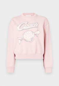 Ροζ κοντή φούτερ με γραφικό σχέδιο που περιλαμβάνει τη λέξη "Coach" και μοτίβο καραμέλας, κατασκευασμένη από μαλακό ύφασμα με ριμπ μανσέτες και τελείωμα.