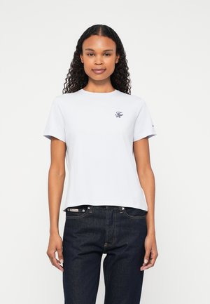 Hellgraues T-Shirt mit kurzen Ärmeln und rundem Halsausschnitt, ausgestattet mit einem kleinen marineblauen Logo auf der Brust. Aus Baumwollmaterial, lockere Passform.