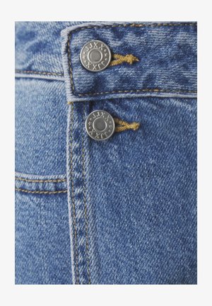 Blauwe denim jeans met twee zilveren metalen knopen bij de taille, gele stiksels en een close-up van de gestructureerde stof.