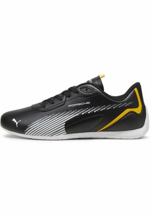 Zwarte sportschoenen met een gladde leren buitenkant, witte en gele accenten, een dynamisch streepjespatroon en een gevoerde kraag.