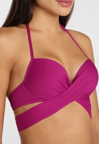 Fialový bikiny top s prekrúteným predným dizajnom, nastaviteľnými tenkými ramienkami a hladkou textúrou; vhodný na plavky.