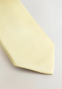 Gul silke slips med en glat tekstur, der har et klassisk design og en spids ende. Stoffet har en subtil glans.