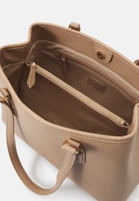 Bolsa tote de couro texturizado marrom com duas alças, bolso com fecho éclair e fecho magnético. Forro interior liso, em bege.