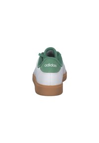 Zapatilla blanca con acentos verdes, parte superior de cuero texturizado, suela de goma y logo "adidas" en el talón. Presenta un diseño de perfil bajo.