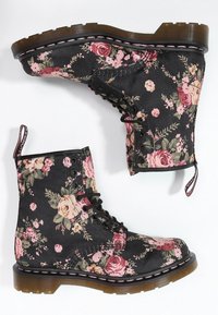 Czarne botki za kostkę w kwiatowy wzór z różowymi różami, zawiązywane na sznurówki, z gumową podeszwą oraz kontrastowym przeszyciem na krawędzi.