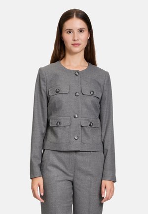 Grau geschnittene Jacke mit rundem Ausschnitt, vier Vorder Taschen und schwarzen Knopfverschlüssen. Texturiertes Gewebe mit glatter Oberfläche.