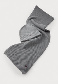 Set de fular și căciulă tricotate cu nervuri gri, prezentând un accent cu un logo mic. Materialul are o textură moale și un model consistent.