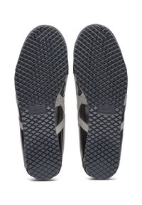 Sneakers neri con suola in gomma texture, caratterizzati da un motivo a rombi. Accenti grigi sui lati e un logo impresso sulla suola.