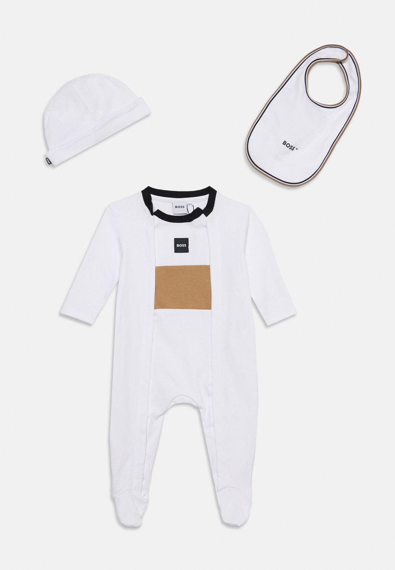 Ensemble pour bébé blanc avec un body à manches longues avec pieds, un bonnet assorti et un bavoir blanc avec bordure noire et détails du logo.