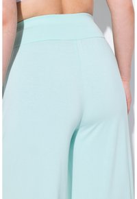 Lichtblauwe brede pijpen pantalons met een zachte, rekbare tailleband, een gladde textuur en zonder zichtbare patronen of accenten.