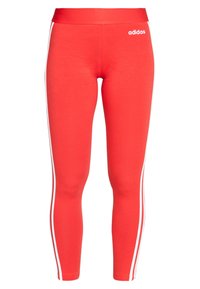 Czerwone legginsy Adidas z białymi paskami po bokach i logo na górnej lewej udzie, dopasowane i do kostek.