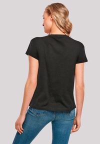 Black cotton t-shirt with short sleeves, a rounded neckline, and a relaxed fit. Back view showing a smooth texture and slight curve at the hem.