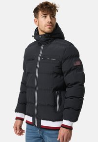 Black puffer jacket with a hood, featuring two zippered chest pockets, a front zipper, ribbed cuffs, and white and red accents.