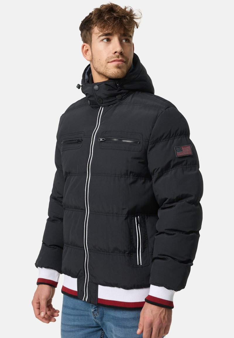 Black puffer jacket with a hood, featuring two zippered chest pockets, a front zipper, ribbed cuffs, and white and red accents.