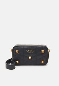 Černá prošívaná syntetická kožená taška se zlatými pyramidovými hroty a zipovým uzávěrem. Obsahuje odnímatelný popruh pro všestranné nošení.