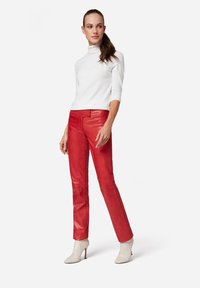 Witte coltrui en glanzende rode leren broek, slim fit ontwerp, enkellang, gecombineerd met off-white hakschoenen.