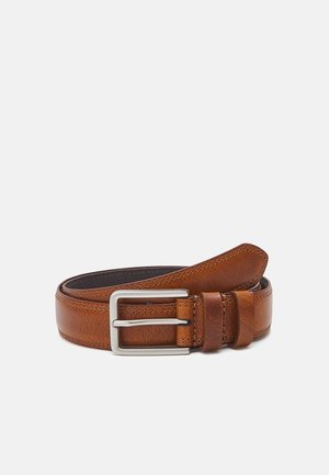 Ceinture en cuir marron roulée avec une boucle rectangulaire argentée sur fond blanc uni.