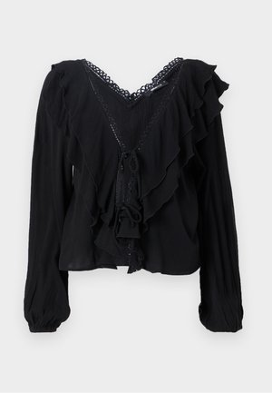 Blusa nera con maniche lunghe, frontale arricciato, scollo a V e chiusura con fiocco. Realizzata in tessuto leggero con dettagli testurizzati e accenti in pizzo.