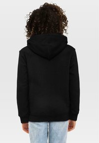 Czarna bluza z kapturem o miękkiej teksturze, z kieszenią kangurką i ściągaczami przy rękawach, widoczna z tyłu.