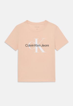 Peach cotton t-shirt with short sleeves, round neck, and a white "CK" logo above the text "Calvin Klein Jeans" in dark gray.