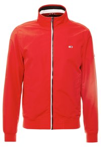 Giacca rossa con zip e colletto alto, polsini e orlo elasticizzati. Presenta un piccolo logo sul petto e una fodera interna a contrasto.