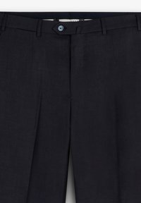 Pantalones de marinero hechos de una tela suave, con un frente plano, dos pliegues y un solo botón azul en la cintura.