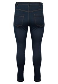 Jeans de mezclilla azul oscuro con un diseño ajustado, que presentan una cinturilla de tiro medio y dos bolsillos traseros con costuras naranjas en contraste.