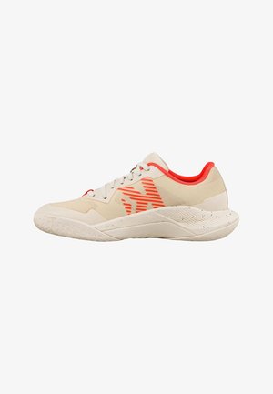 Beige sportschoen met oranje gestreept logo, oranje binnenvoering, witte veters en een gestructureerde zool, ontworpen voor sport of casual gebruik.
