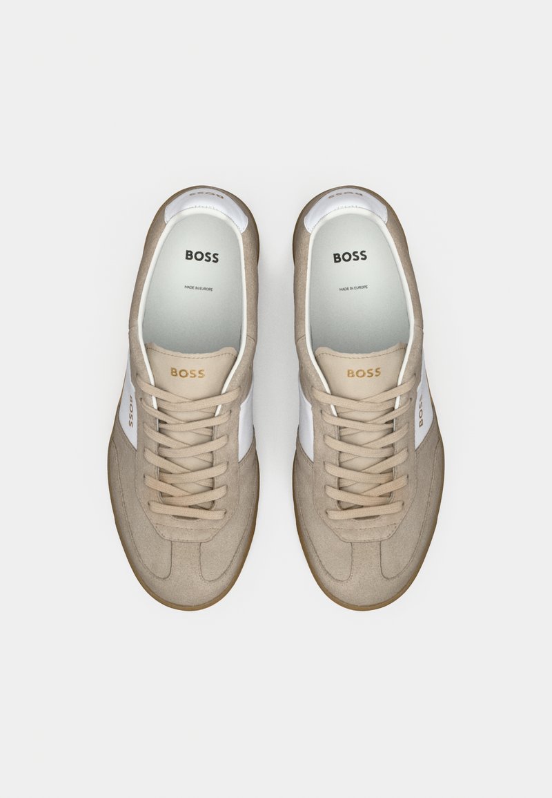 Sneaker in suede beige con dettagli in pelle bianca, punta rotonda, lacci piatti e marchio "BOSS" sulla linguetta e sul lato. Suola in gomma.