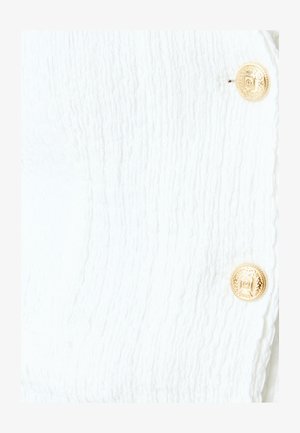 Tejido blanco texturizado con un patrón acanalado, que presenta dos botones dorados con un diseño decorativo para el cierre.