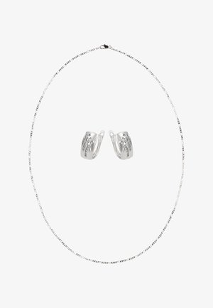 Zilveren ketting met een dun ontwerp van schakels en een sluiting, vergezeld van bijpassende oorbellen met een getextureerd oppervlak en een geometrisch patroon.