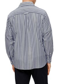 Heren langslijfshirt in marineblauw en wit gestreept patroon. Voorzien van een button-down kraag, gestructureerde stof en aangeknoopte mouwen.