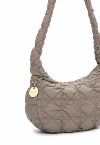 Quilted beige handbag with a soft texture, curved shape, and a chain accent. Features diamond patterns and a metal tag.