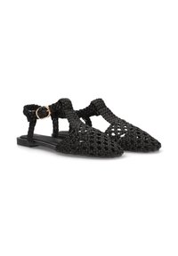 Sandalias planas de tejido negro con un diseño abierto, punta afilada y tira en el tobillo con un detalle de hebilla en tono dorado. Adecuadas para uso casual.