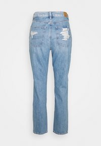 Jean en denim bleu clair à coupe droite, avec des patchs usés sur les poches arrière et une finition texturée.