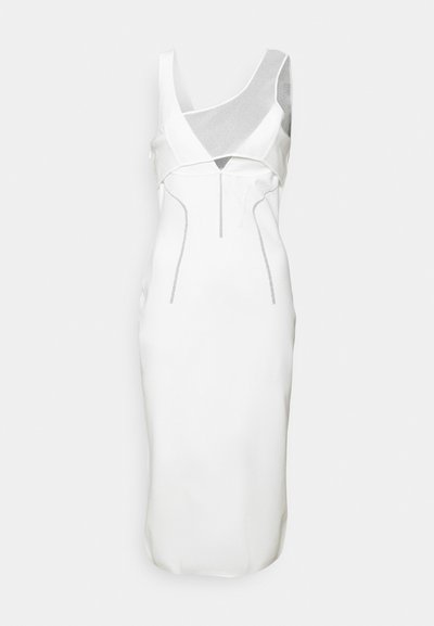 Abito bianco con una silhouette aderente, caratterizzato da un mix di tessuti lisci e testurizzati, ritagli angolari e dettagli in argento.