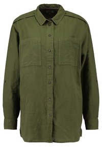 Camicia verde a maniche lunghe in tessuto texturizzato. Presenta due tasche anteriori, pattine sulle spalle e un logo lungo la patta di chiusura.