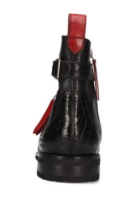 Botín de piel negra con textura de cocodrilo, acento rojo en el tacón, detalle de hebilla plateada y suela negra robusta.
