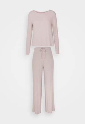 Lyserødt loungewear sæt bestående af en langærmet ribbet top med rund halsudskæring og bukser med snøre i flared ben. Blød tekstur.