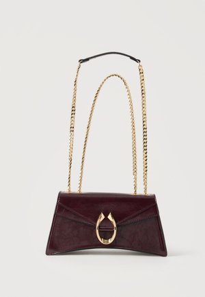 Borsa a mano in pelle bordeaux scuro con chiusura a ferro di cavallo dorata e doppi manici a catena dorati su sfondo bianco semplice.