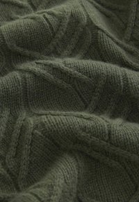 Dunkelgrüner gestrickter Stoff mit einem strukturierten Muster, das erhabene Linien aufweist und eine weiche, dicke Erscheinung hat, die Wärme und Gemütlichkeit betont.