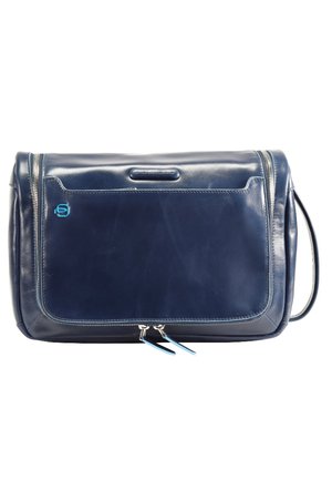 Borsa a tracolla in pelle blu navy con texture liscia, tasca frontale con zip, accento logo blu e doppie zip. Include una tracolla regolabile.