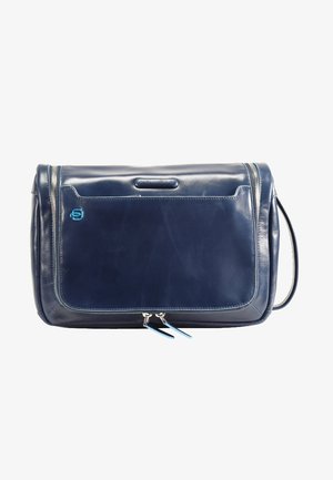 Borsa a tracolla in pelle blu navy con texture liscia, tasca frontale con zip, accento logo blu e doppie zip. Include una tracolla regolabile.